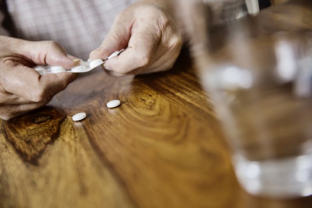 Белые таблетки и стакан воды